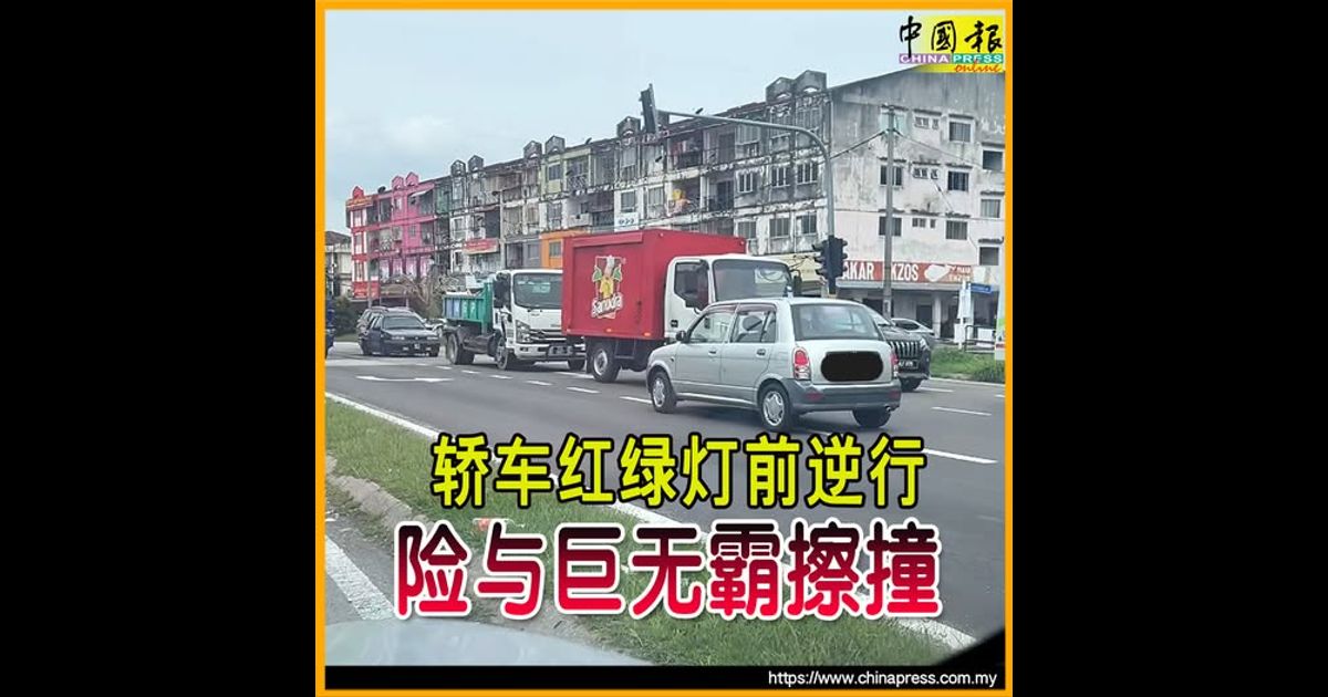 轿车红绿灯前逆行 险与巨无霸擦撞